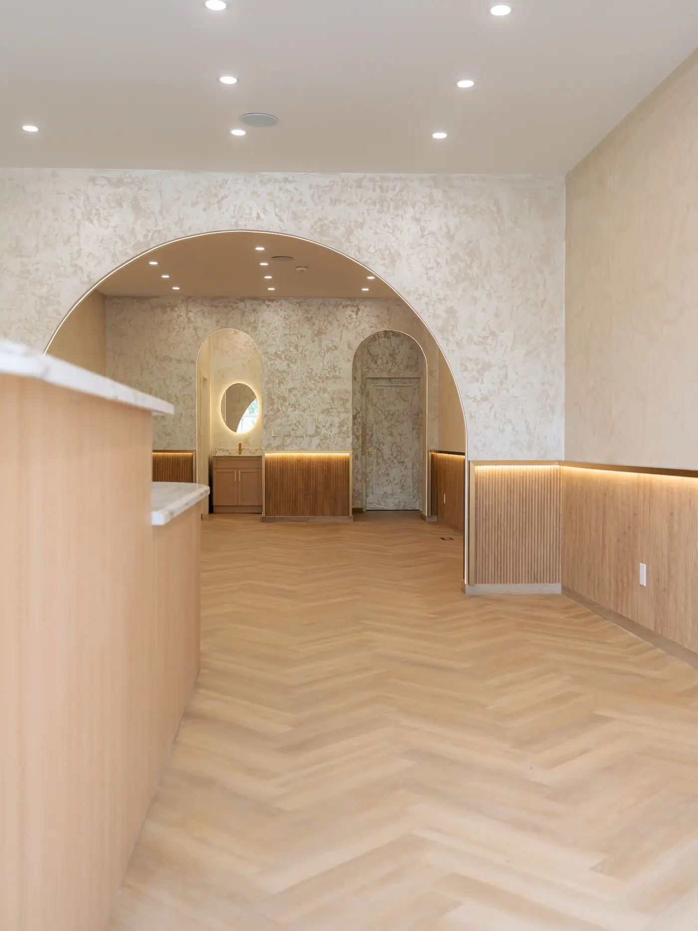 Fluted oak reception counter under an arch