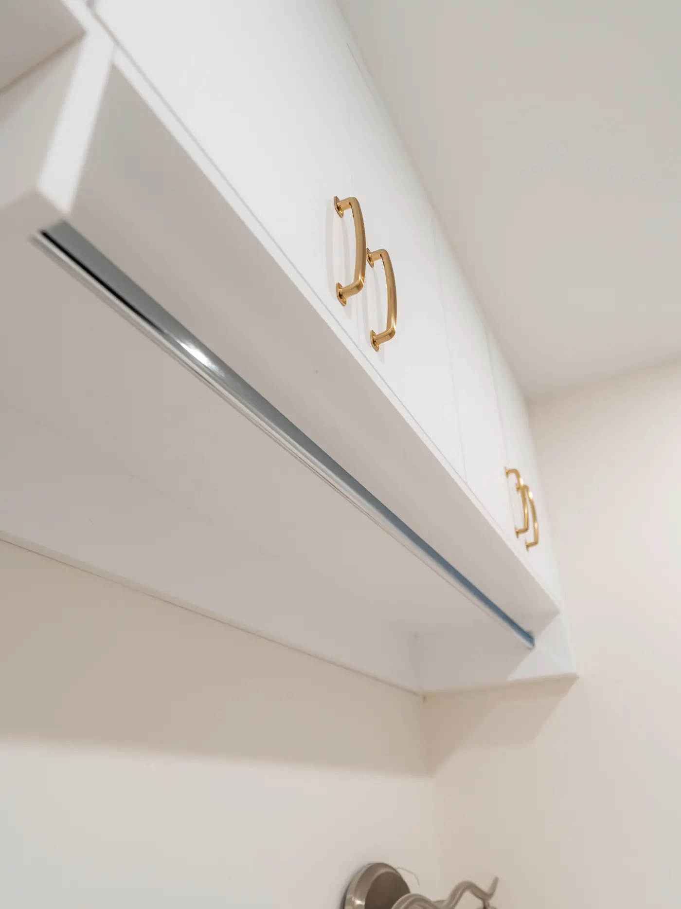 White lacquer cabinetry with brushed gold pulls